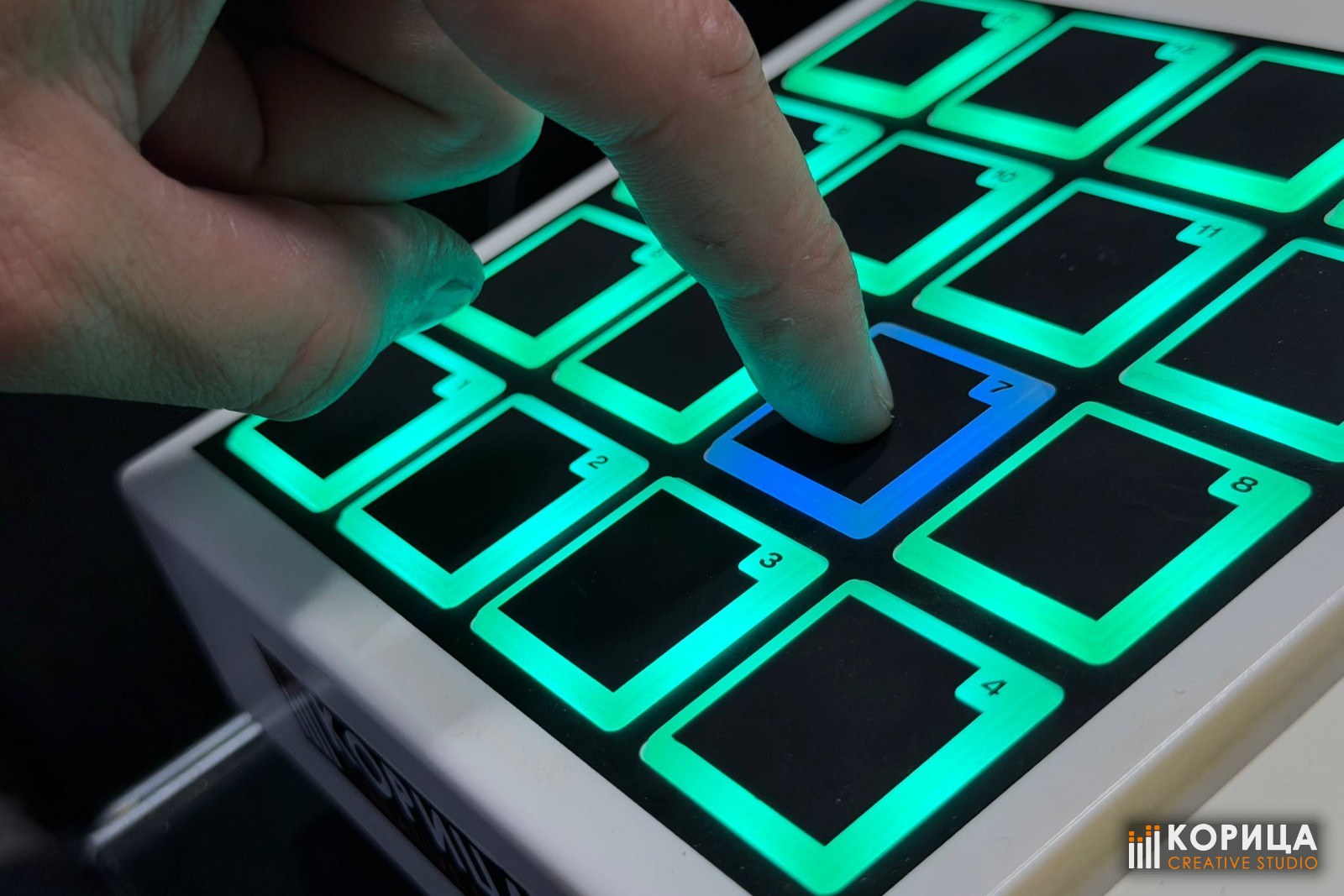 Палец нажимает подсвеченный пэд MIDI-контроллера в студии «Корица»